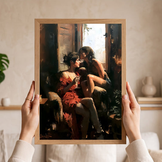 A framed art print depicting two women in a warm, sunlit interior, held up by two hands against a softly blurred home background.