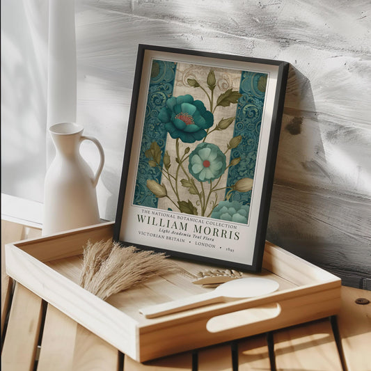 Framed botanical print by William Morris on a wooden tray with decorative items.A framed botanical print showcasing teal flowers with red centers and green foliage. The print is from the William Morris collection, with text indicating "Victorian Britain" and "London 1895". The artwork has a vintage style.
