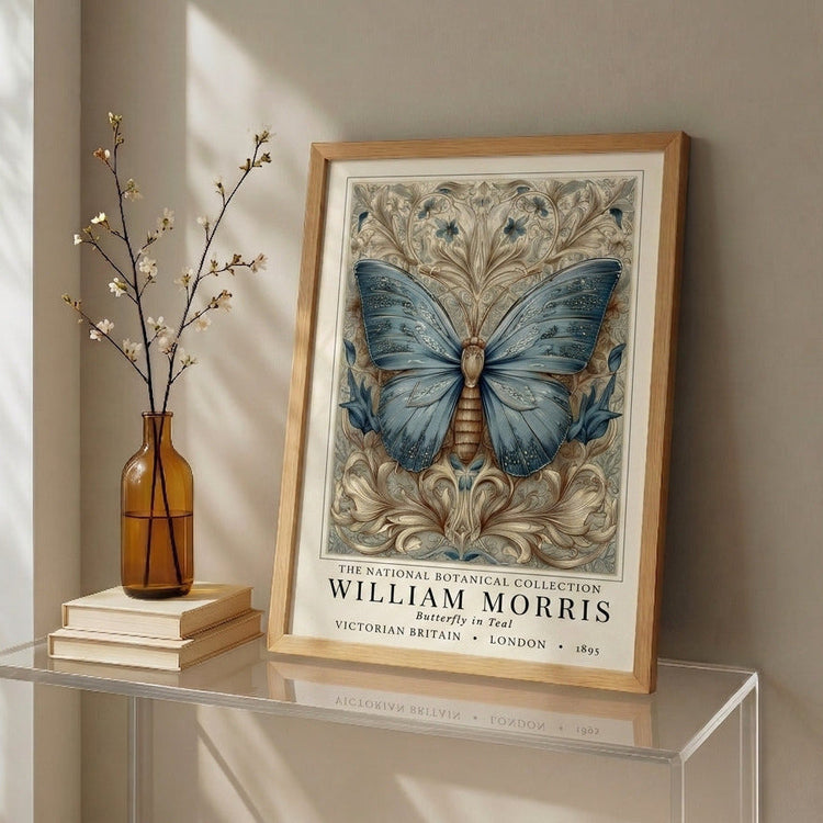 Framed artwork inspired by William Morris, of a butterfly on a table with a vase and books in the background