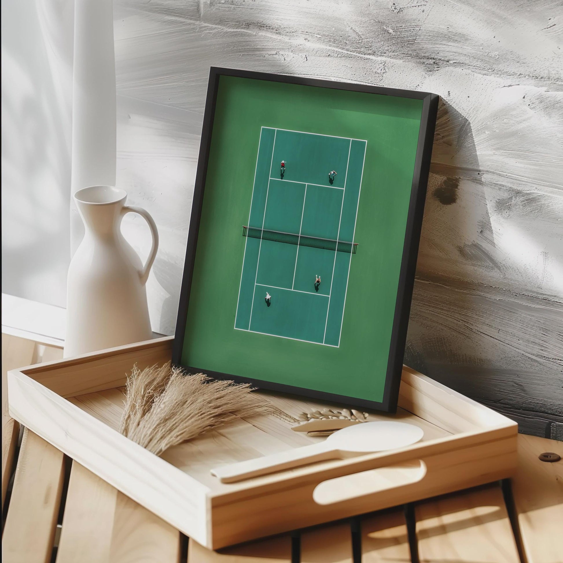 Framed artwork of a tennis court on a wooden tray with decorative items Framed artwork of a tennis court in miniature from above 
