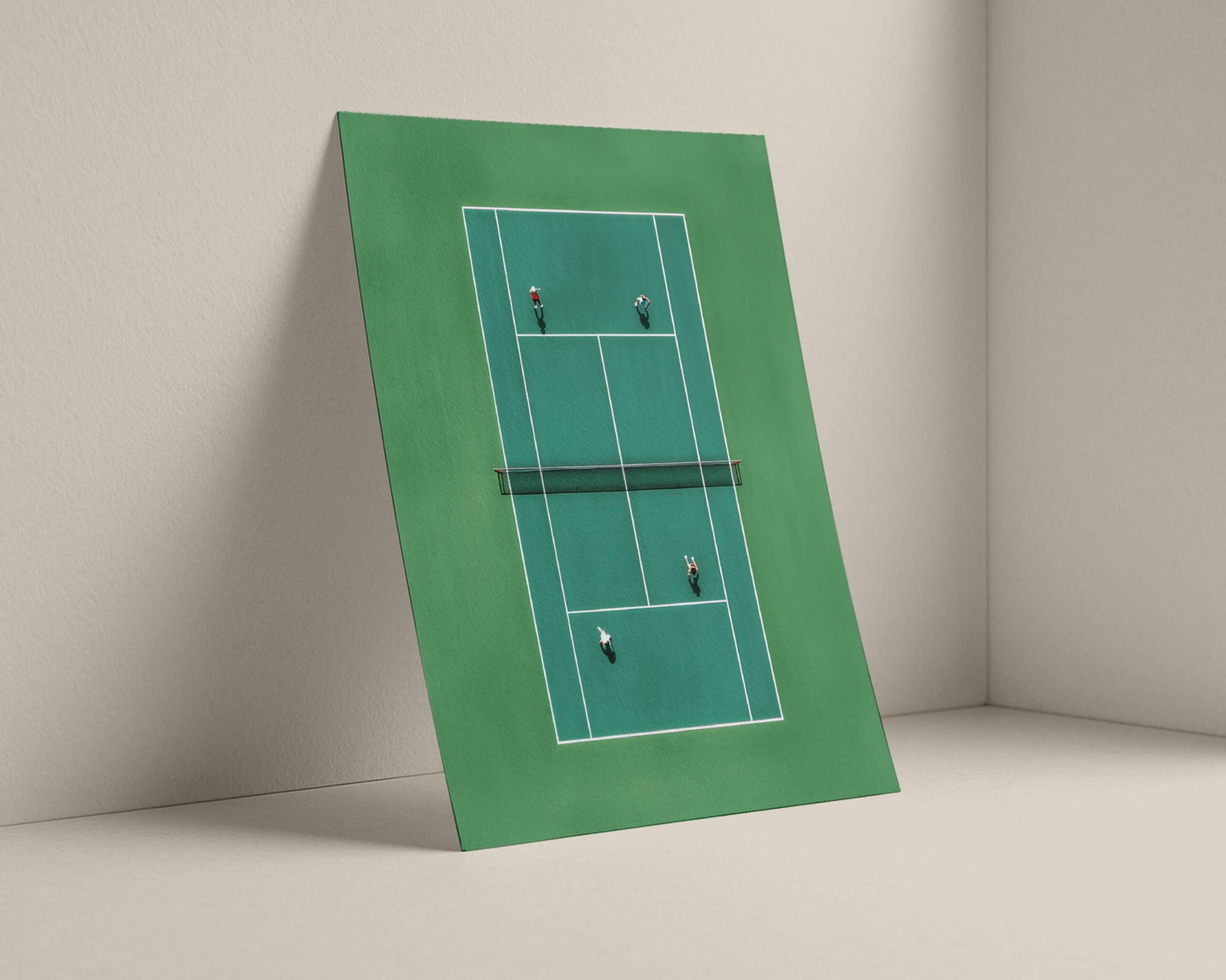 Framed picture of a tennis court with players on a beige wall.