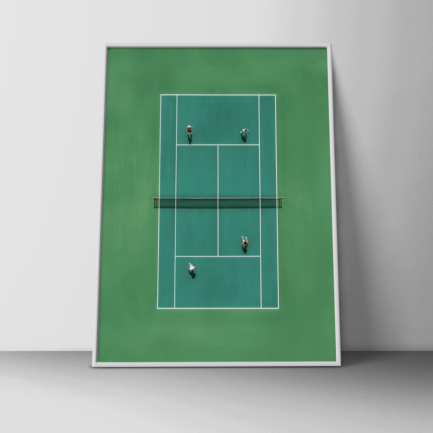 Framed artwork of a tennis court with players on a white wall.