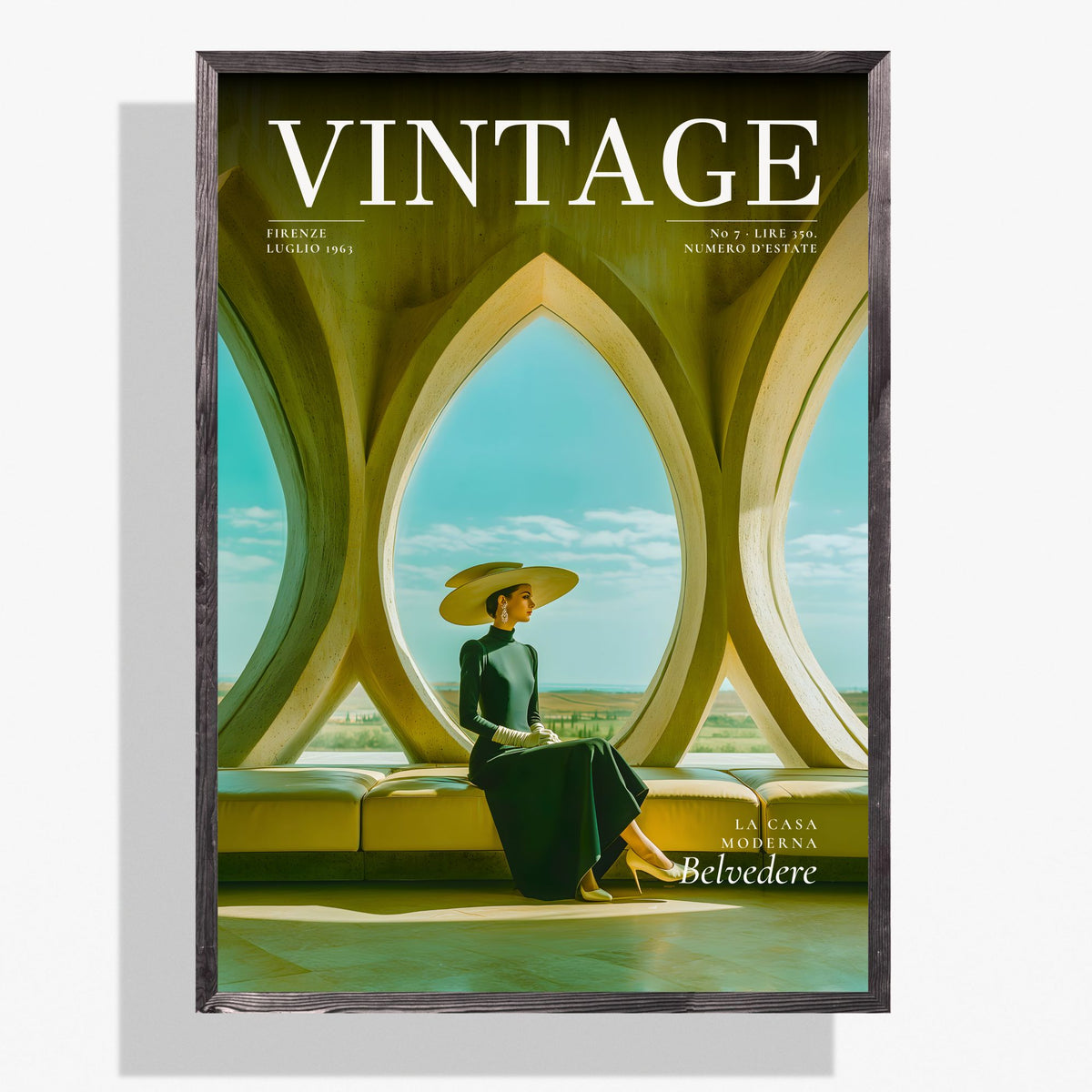 A framed vintage-style magazine cover titled VINTAGE, featuring a seated woman in a wide-brimmed hat inside an architectural interior with large arched windows. The cover is shown hanging against a light gray wall with a soft shadow.