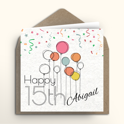 Greeting card with colorful balloons and 'Happy 15th Abigail' text on a white background with a brown envelope.