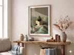 Painterly poster of a black cat reading a book in bed with sage green striped pillows, mint sheets and a cream morning mug of tea.