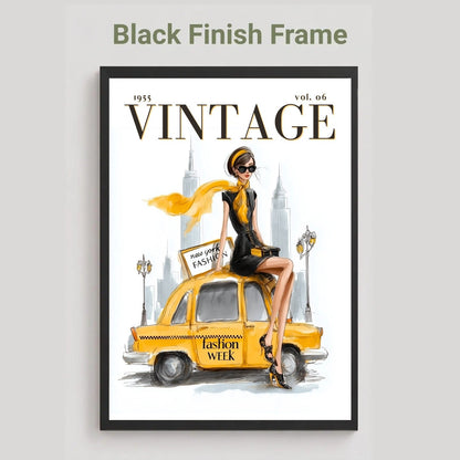 A framed vintage-style fashion poster on a light gray background, with the text 'Black Finish Frame' above it. The poster shows a woman in a black outfit sitting on a yellow taxi with 'VINTAGE' across the top and a white city skyline behind her.