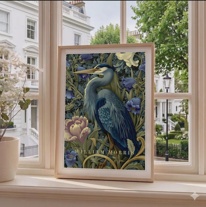 Framed artwork of a blue heron among flowers on a windowsill with a view of a building and trees outside. Blue heron among peonies and campanula in Victorian Arts & Crafts botanical style — dark teal, navy and olive art print