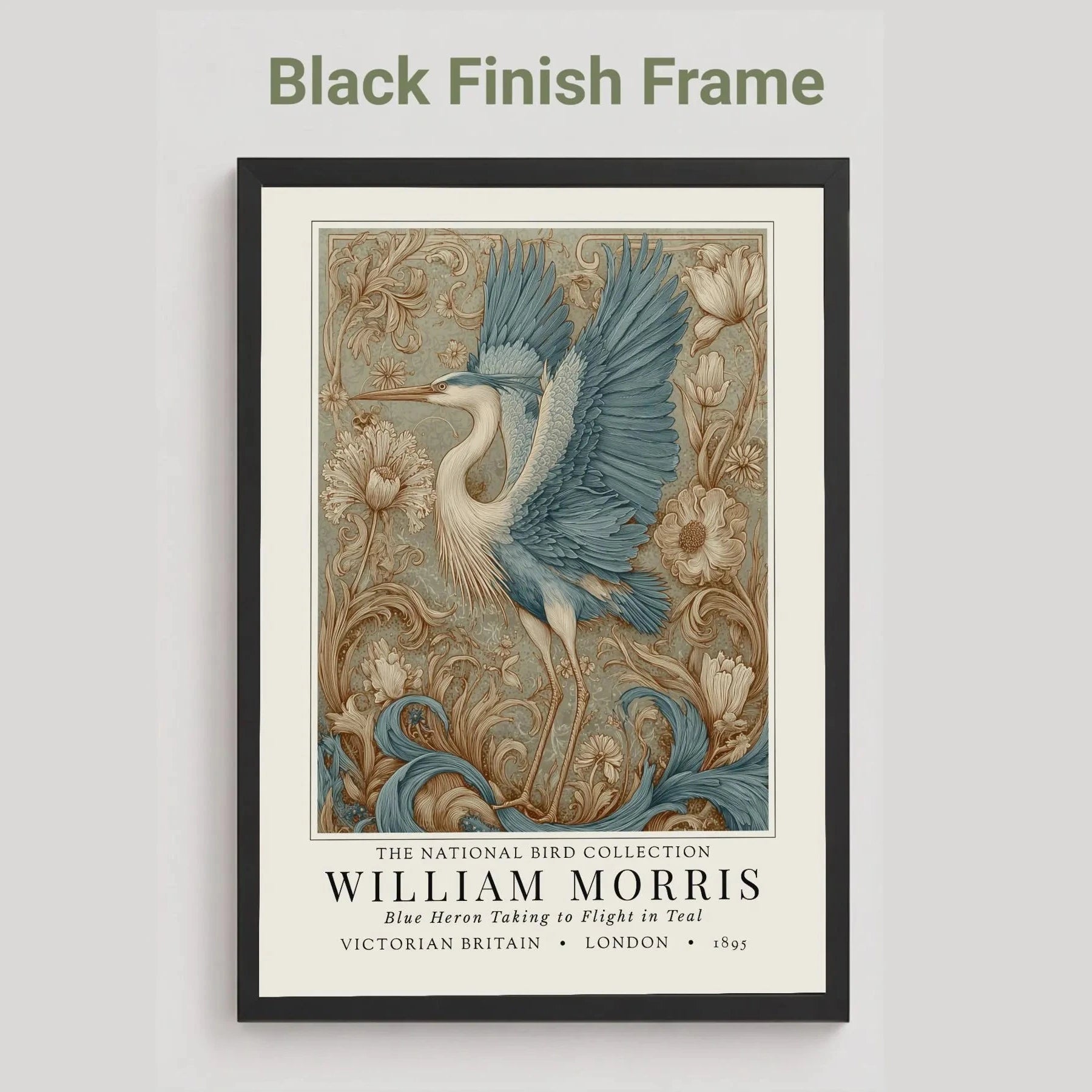 Black framed artwork of a blue heron with decorative elements on a light gray background. William Morris style exhibition poster featuring a blue heron taking to flight, surrounded by ornate acanthus scrolls, dahlias and botanical foliage in teal, gold and antique cream — Arts & Crafts wall art print