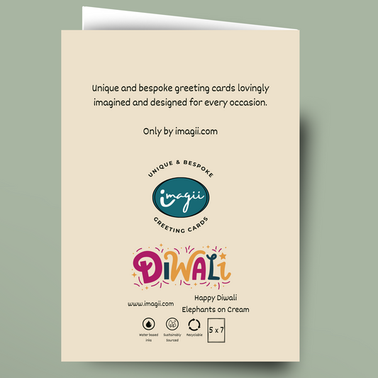 A cream-colored greeting card shown against a muted sage green background. The card features black descriptive text at the top, the 'imagii' logo in the center, and a colorful 'Diwali' title with 'Happy Diwali Elephants on Cream' at the bottom.