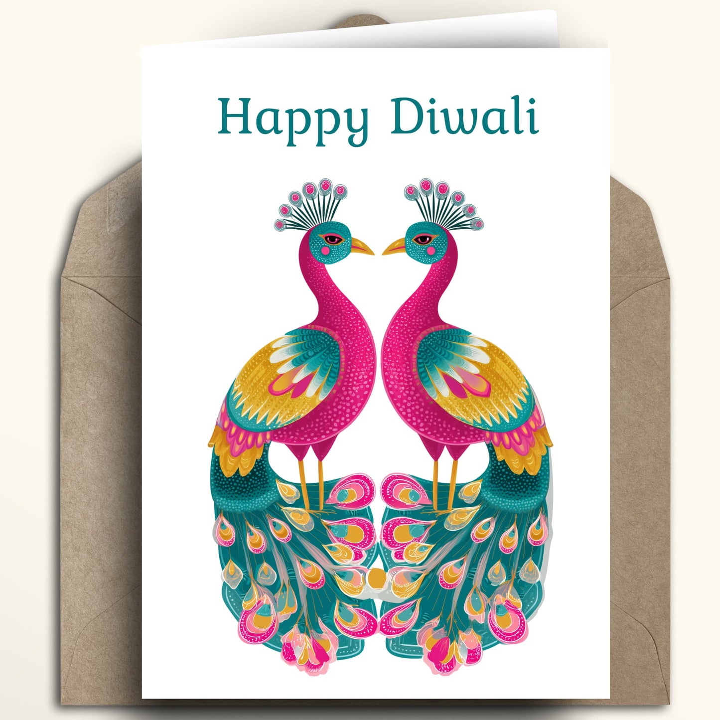A Diwali greeting card with the text 'Happy Diwali' at the top, featuring two colorful peacocks facing each other on a white card, shown with a brown envelope behind it.
