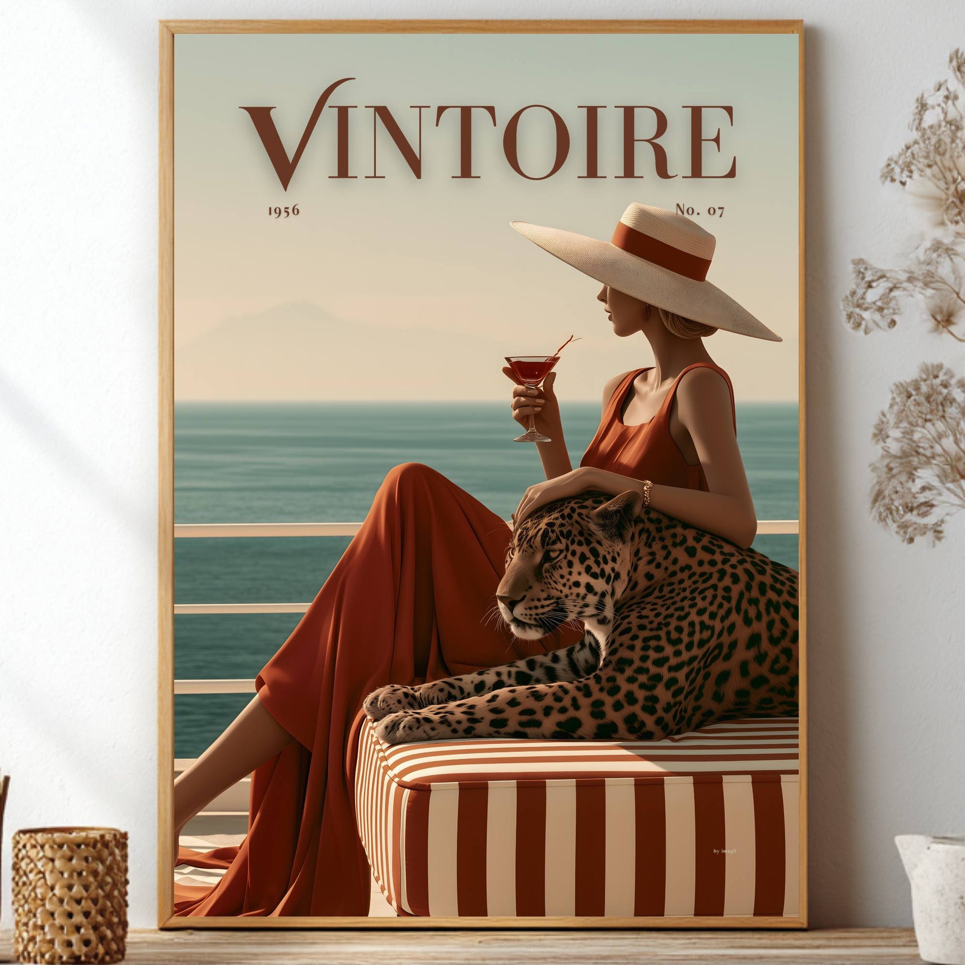 Framed poster of a faux magazine cover featuring a woman holding a cocktail with a leopard by the ocean, featuring the title 'Vintoire'.