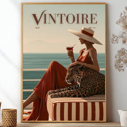 Framed poster of a faux magazine cover featuring a woman holding a cocktail with a leopard by the ocean, featuring the title 'Vintoire'.