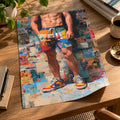 Unframed Front Page poster with a gently curled edge lying on a wooden desk beside a plant, books and a coffee cup, showing a man in patchwork shorts and trainers.