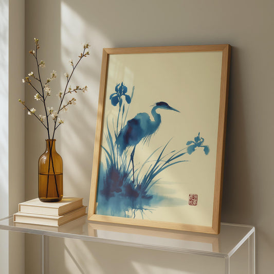 Framed artwork of a blue heron and flowers on a table with a vase and books. Heron Watercolour Print Blue Japanese Ink Art Poster | Crane Bird Wall Art | Iris Flower Nature Print