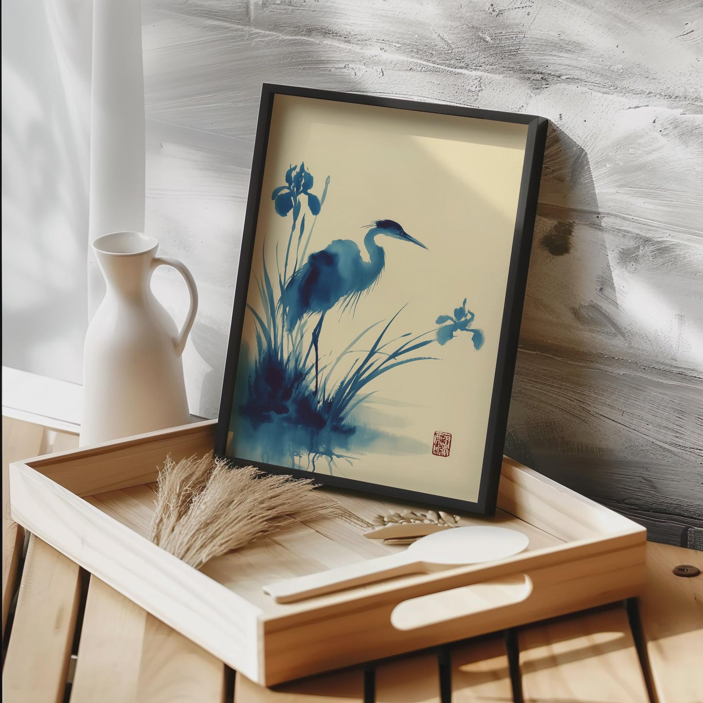 Framed artwork of a blue heron and flowers on a wooden tray with a white vase in the background. Heron Watercolour Print Blue Japanese Ink Art Poster | Crane Bird Wall Art | Iris Flower Nature Print