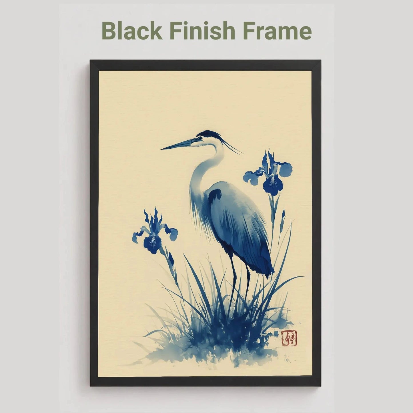 black Framed artwork of a heron and iris flowers with a black finish frame on a beige background. Blue heron and water iris sumi-e print in indigo and cream — Japanese watercolour wall art with cinnabar seal