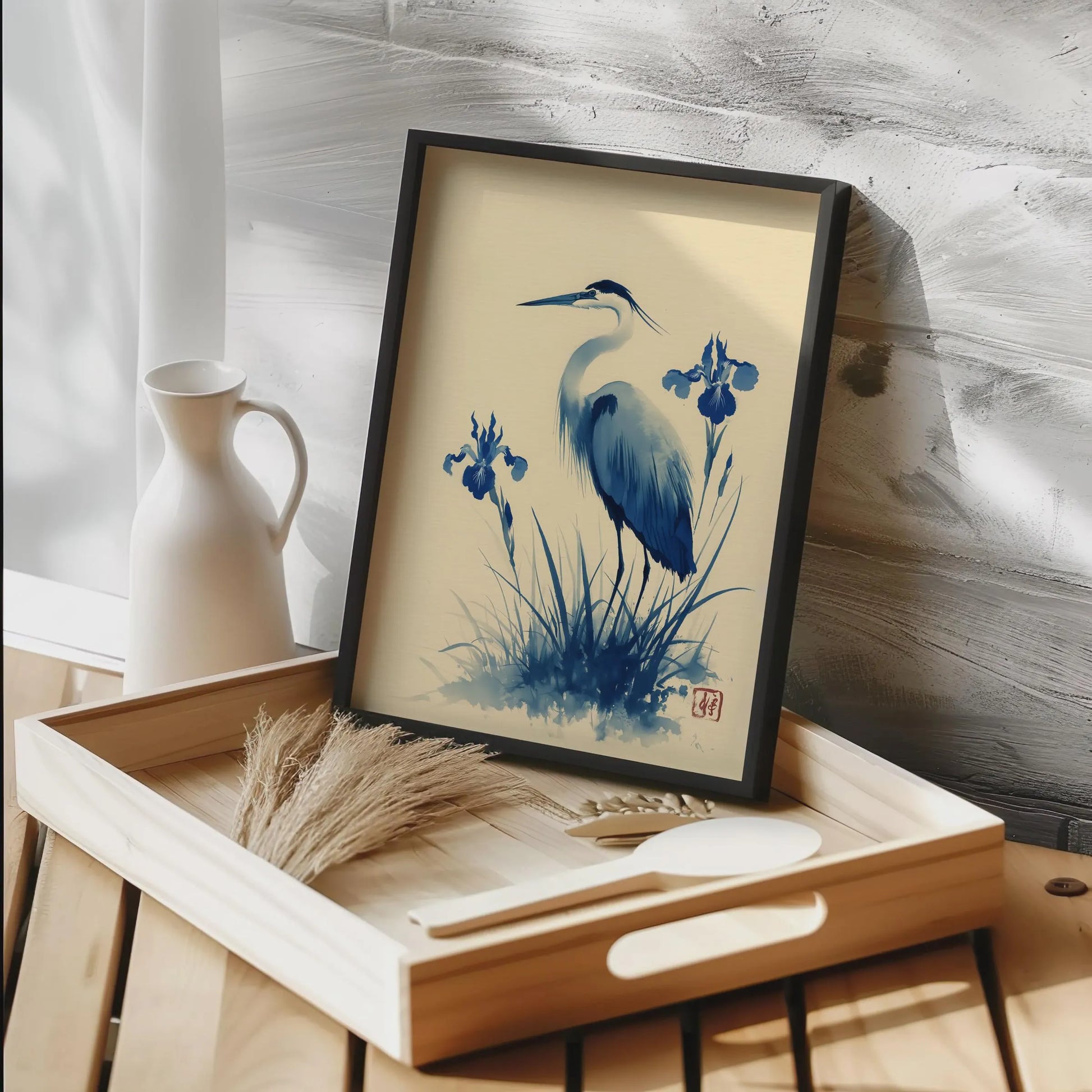 Framed artwork of a heron and iris flowers on a wooden tray with a neutral background. Blue heron and water iris sumi-e print in indigo and cream — Japanese watercolour wall art with cinnabar seal