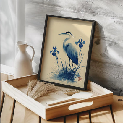 Framed artwork of a heron and iris flowers on a wooden tray with a neutral background. Blue heron and water iris sumi-e print in indigo and cream — Japanese watercolour wall art with cinnabar seal