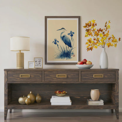 Wooden console table with decorative items including a lamp, framed art, and vases. Blue heron and water iris sumi-e print in indigo and cream — Japanese watercolour wall art with cinnabar seal