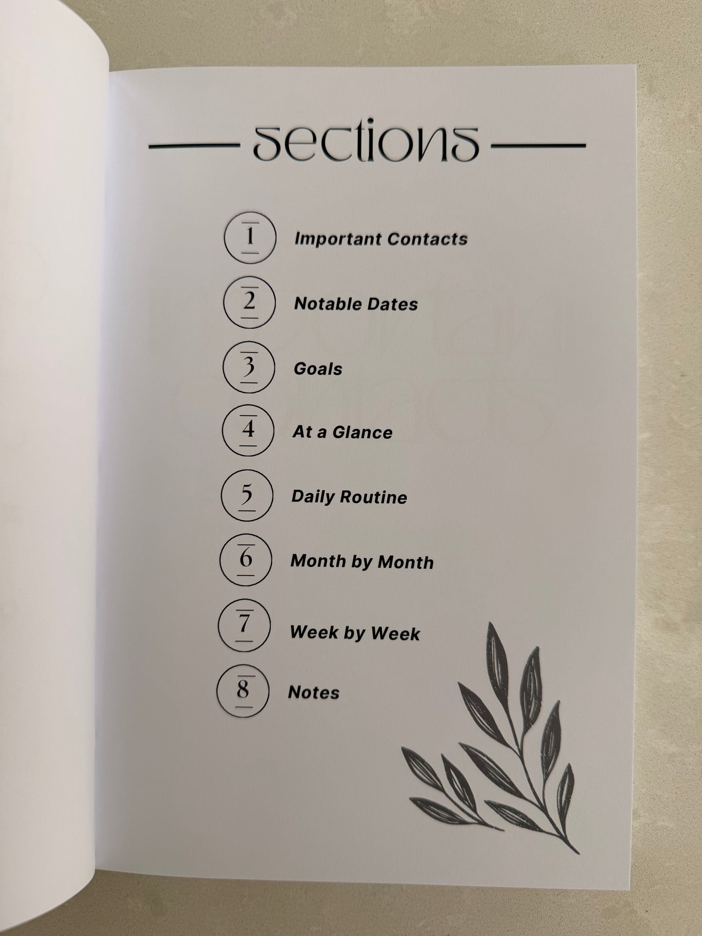 Page from a planner or journal showing section titles and a leaf illustration.