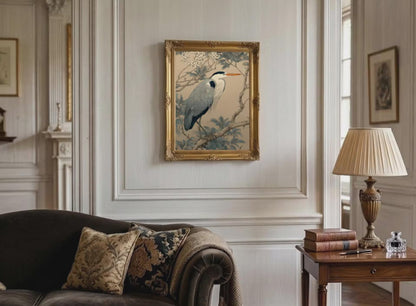Living room with a framed artwork of a heron on the wall, a lamp, and books on a table.