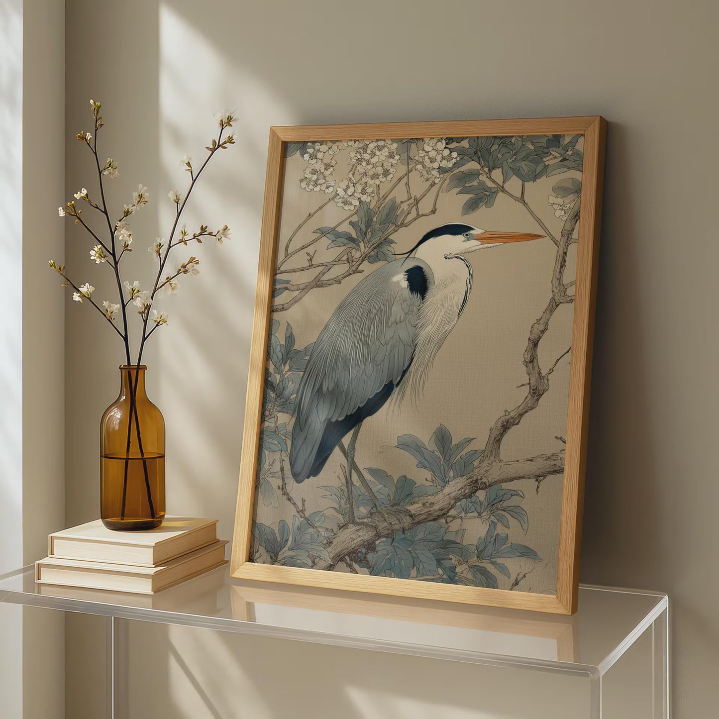 Framed artwork of a heron on a table with a vase and books.