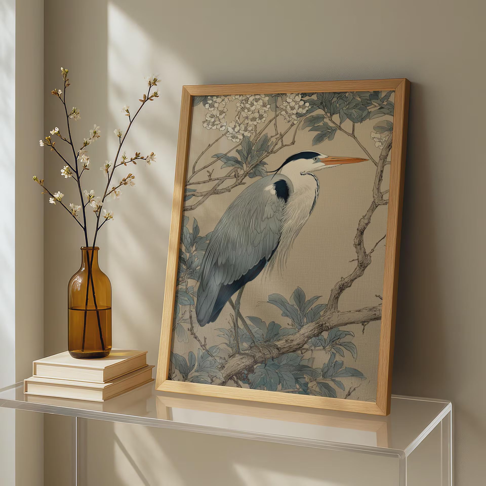 Framed artwork of a heron on a table with a vase and books.