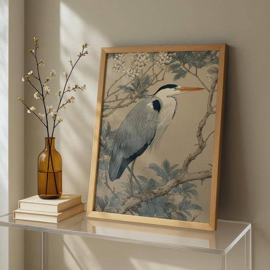 Framed artwork of a heron on a table with a vase and books.