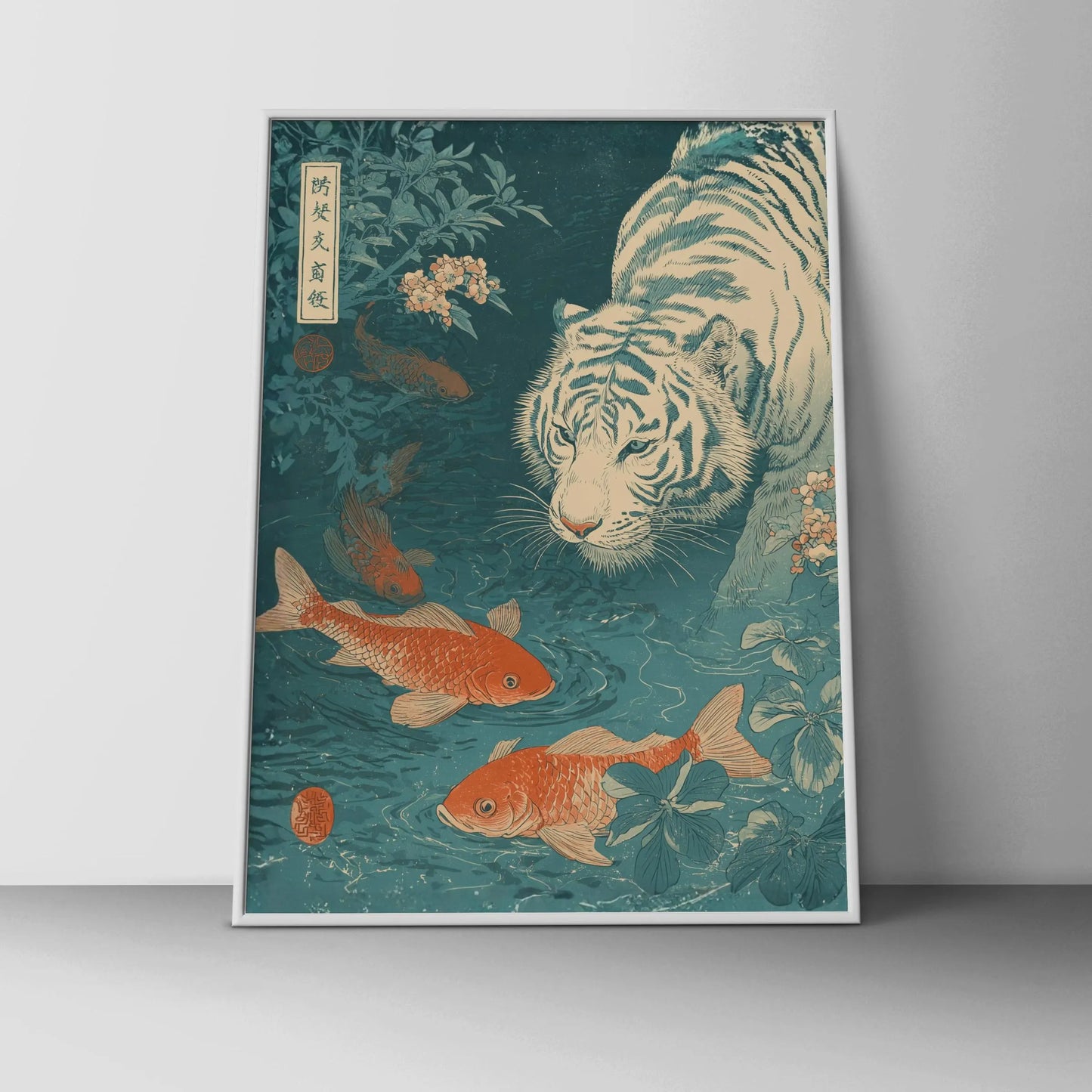 Framed artwork of a tiger and koi fish in a pond on a gray wall. Japanese woodblock-style art print of a white tiger gazing into a teal koi pond, with three orange koi fish swimming in the foreground, cherry blossoms, lush foliage, and traditional Japanese calligraphy seals, in a deep teal and burnt-orange palette.