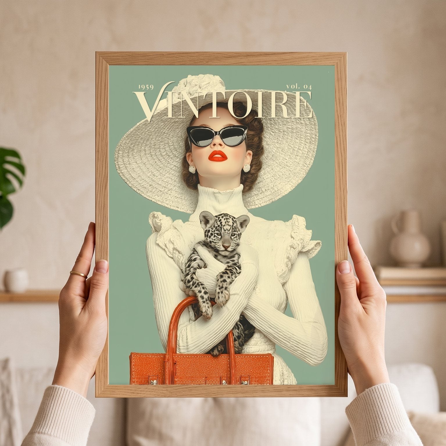 A person holds a framed vintage-style art print featuring a woman in a large hat and sunglasses holding a leopard cub, with the text 'VINTOIRE' and '1959 vol. 04' on a mint background.