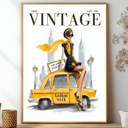 A framed vintage-style fashion poster displayed on a shelf in a styled interior. The poster features the word VINTAGE at the top and an illustration of a woman in a black dress and yellow scarf sitting on a yellow taxi with New York City skyline elements in the background.