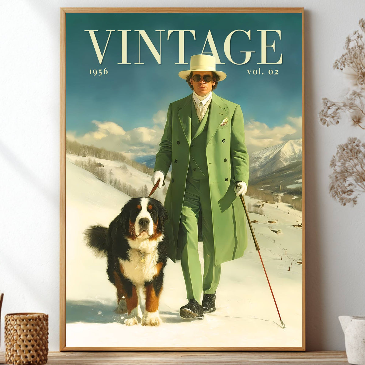A framed vintage-style poster print leaning on a shelf, showing a man in a green suit and hat walking a Bernese mountain dog in a snowy landscape. The poster has the word 'VINTAGE' at the top and is displayed in a styled interior with dried flowers and decorative objects.