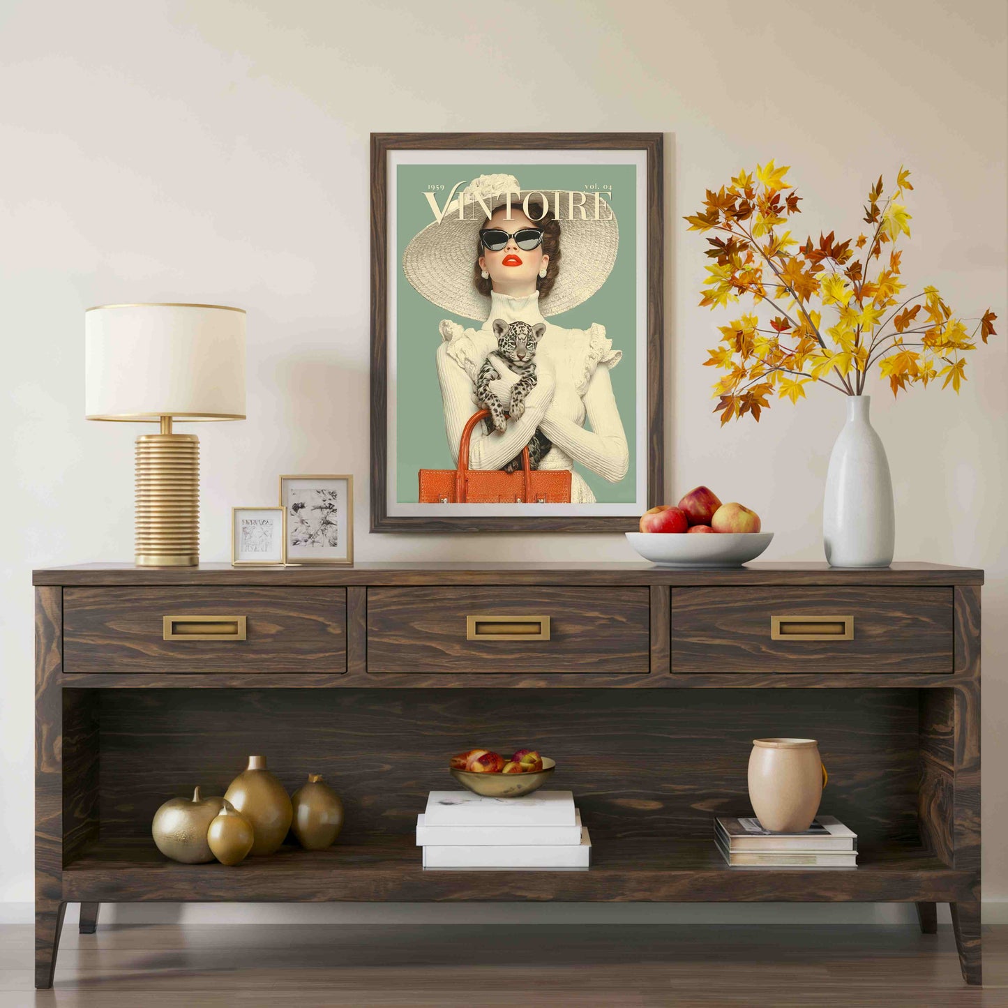 A dark brown wooden console table styled in a living room setting, featuring a framed vintage 'Vivienne' poster, a table lamp, decorative vases, books, and fruit on top and in the open shelf below.