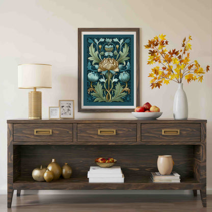 A framed botanical art print with a dark wood frame hangs on a beige wall above a dark wood console table styled with a lamp, fruit, and a vase of autumn leaves.