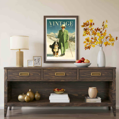 A framed vintage-style magazine cover print hangs on a beige wall above a dark wood console table. The poster reads "VINTAGE" and shows a man in a green coat standing in a snowy landscape with a dog.