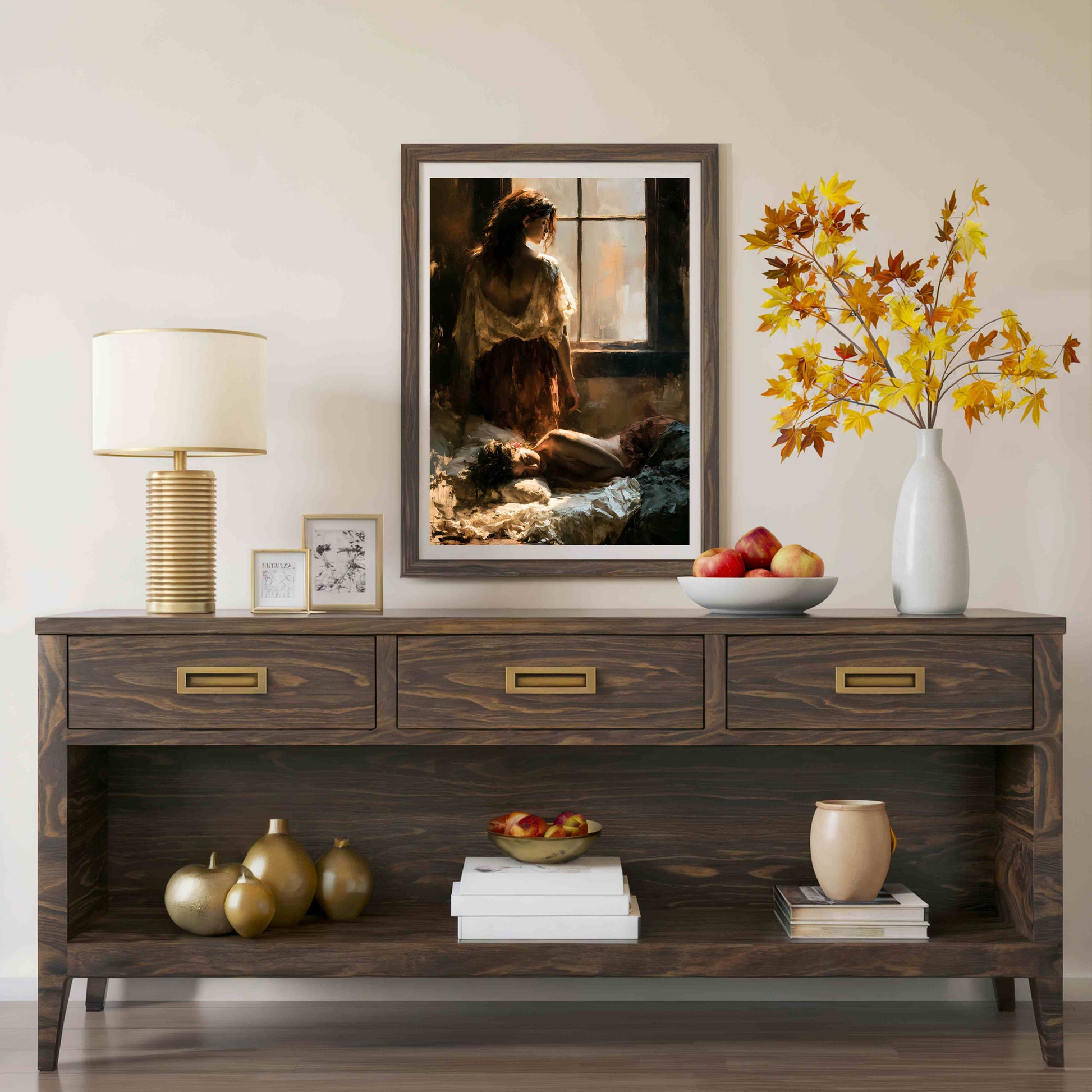 A dark wood console table styled in a living room setting, featuring a framed art print of a woman by a window, a table lamp, a white vase with autumn leaves, and decorative accents on the shelves.