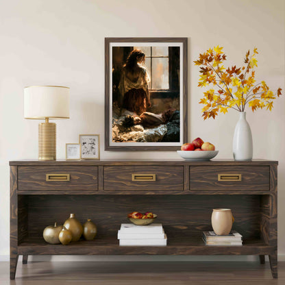 A dark wood console table styled in a living room setting, featuring a framed art print of a woman by a window, a table lamp, a white vase with autumn leaves, and decorative accents on the shelves.