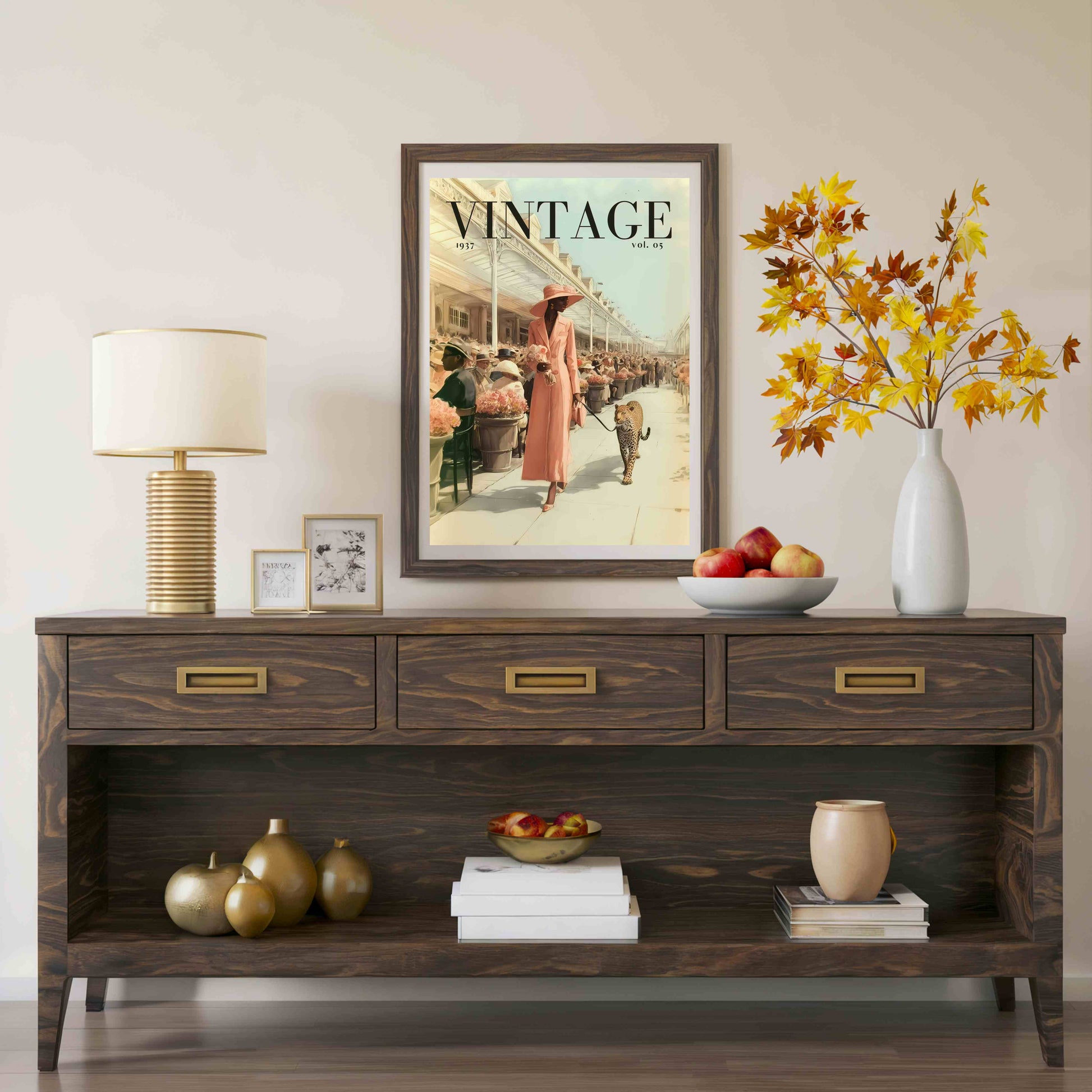 A dark brown wooden console table styled in a living room setting, featuring a vintage 'Vintage' magazine poster hanging above it, a table lamp, decorative vases, and fruit bowls.