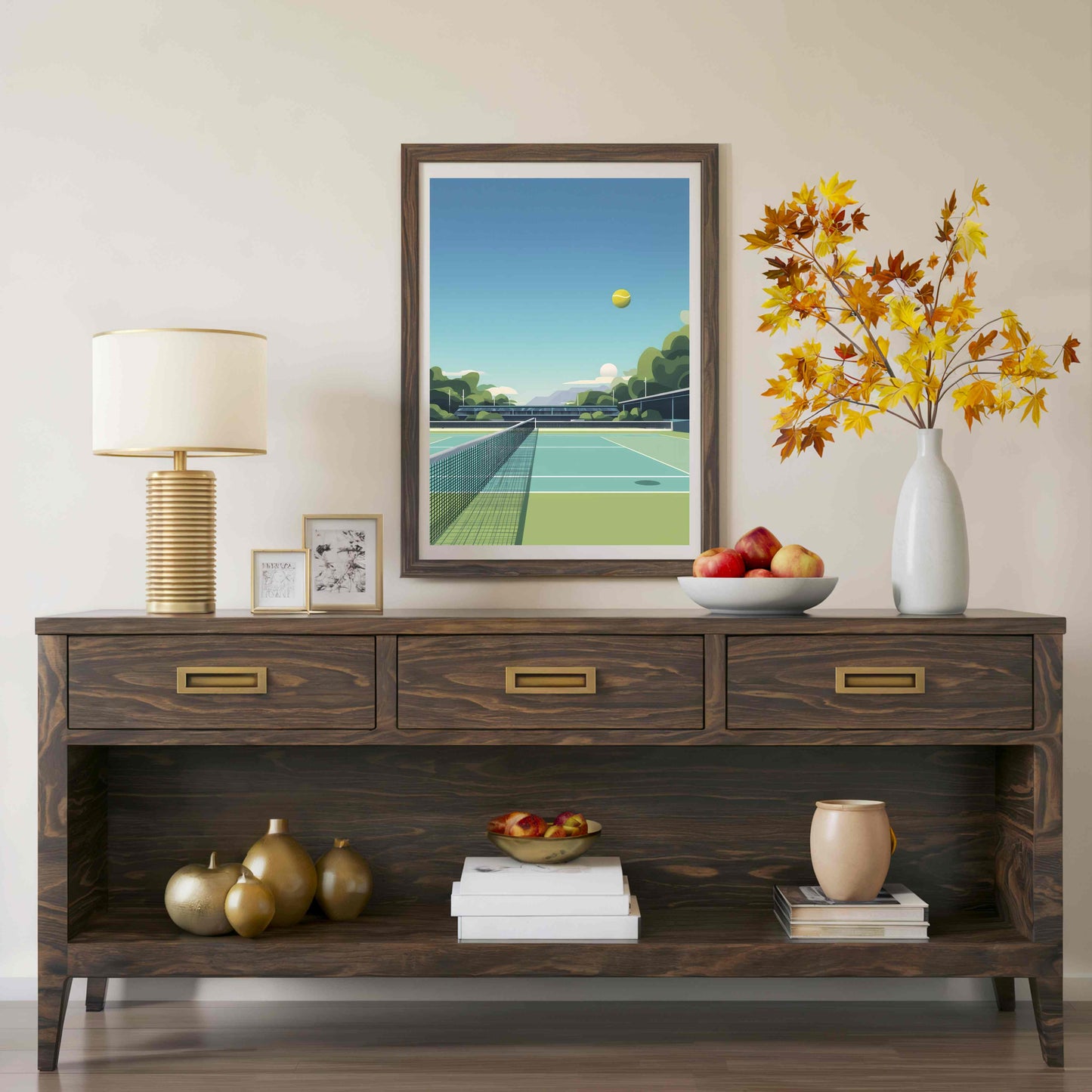A dark brown wooden console table styled in a living room setting, featuring a framed tennis art print on the wall above it, a table lamp, decorative vases, books, and fruit.