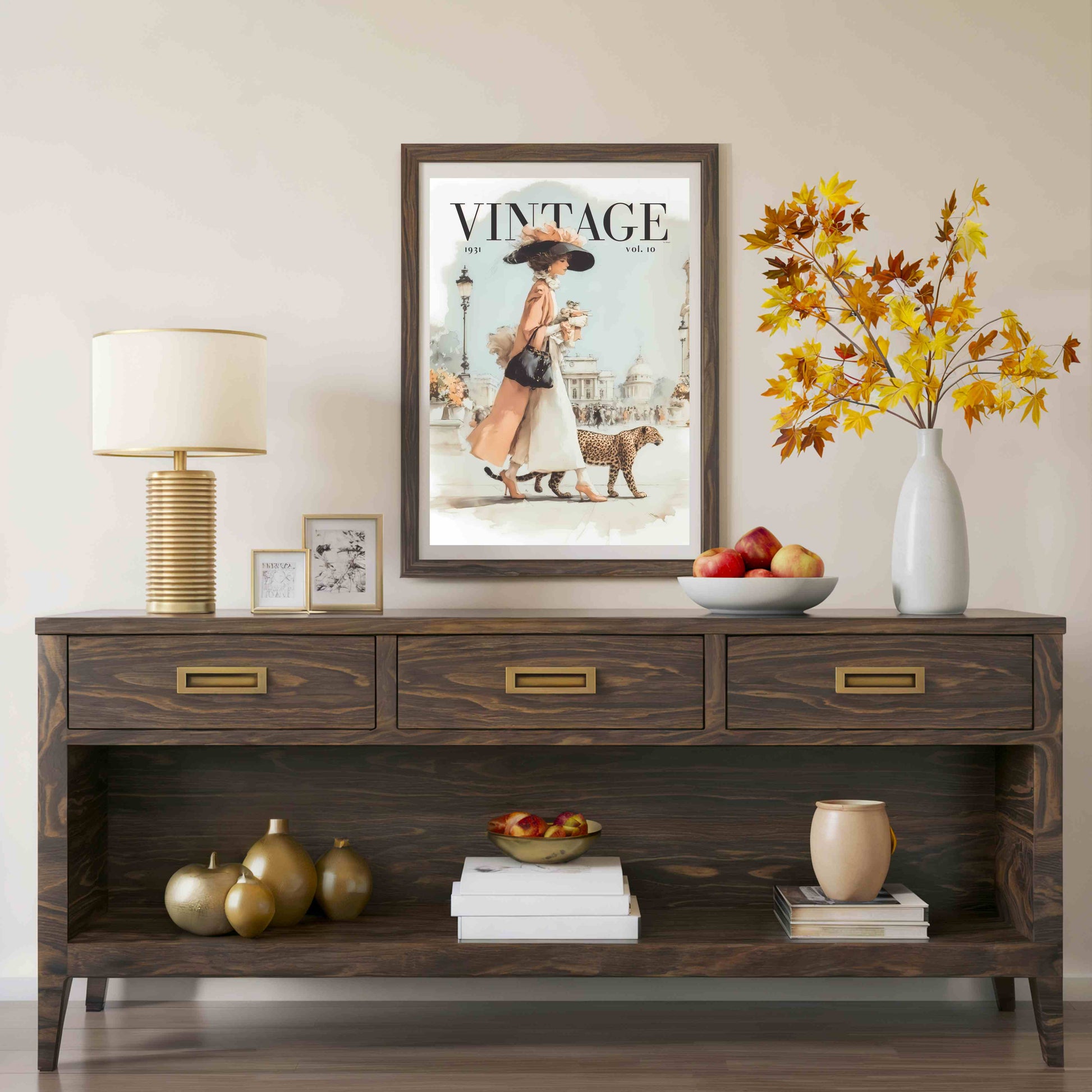 A dark brown wooden console table styled in a living room setting, featuring a vintage 'Vintage Vogue' magazine cover hanging on the wall above it, a table lamp, decorative vases, and fruit bowls.