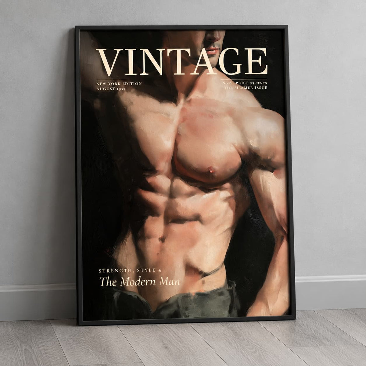 A framed vintage-style poster leaning against a light gray wall on a pale wood floor. The poster features a muscular male torso with the word 'VINTAGE' across the top and additional text including 'The Modern Man'.