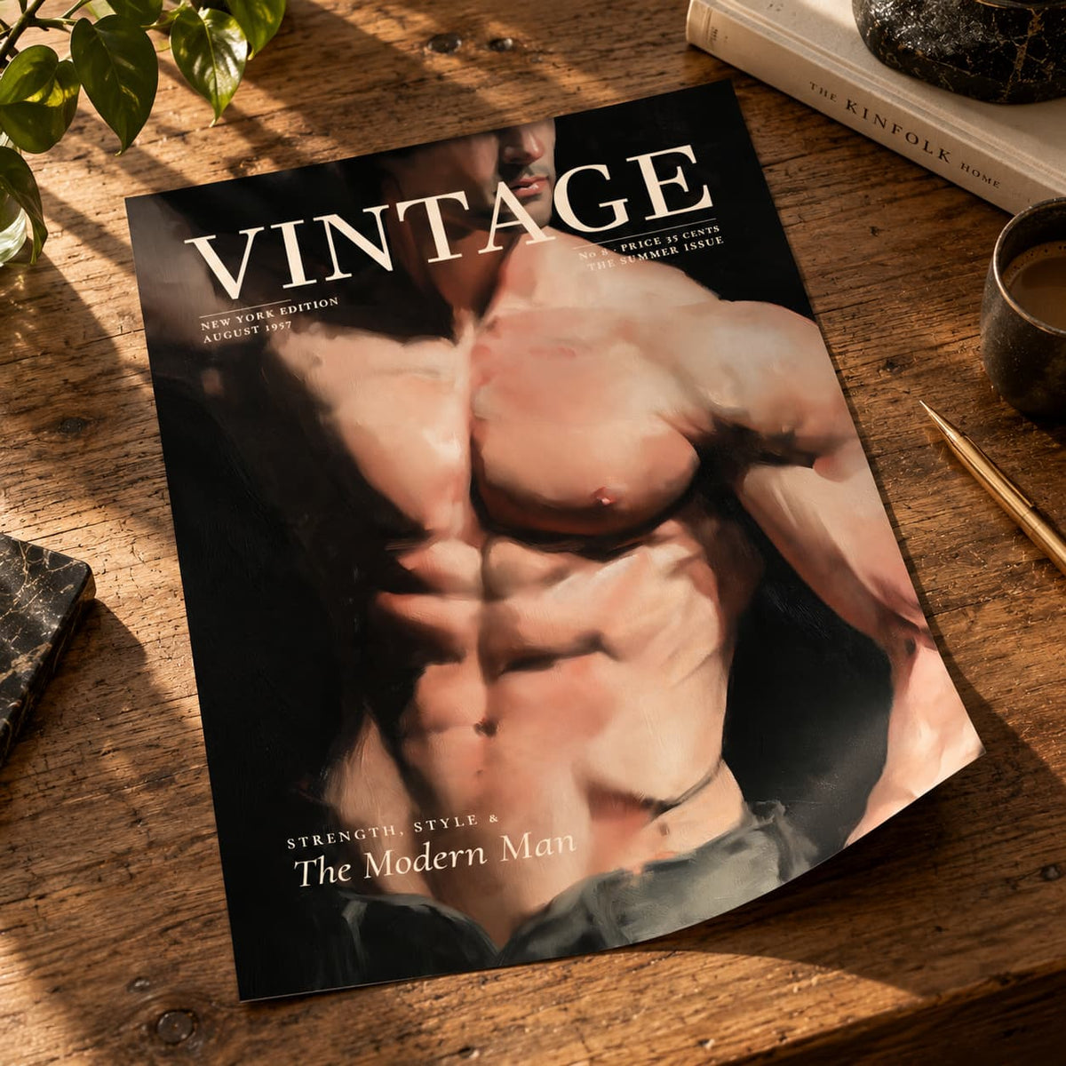 A vintage-style magazine or book cover titled "VINTAGE" lies on a rustic wooden table, featuring a muscular male torso on the cover. The scene is styled with a book, a dark stone object, green leaves, and a cup nearby.