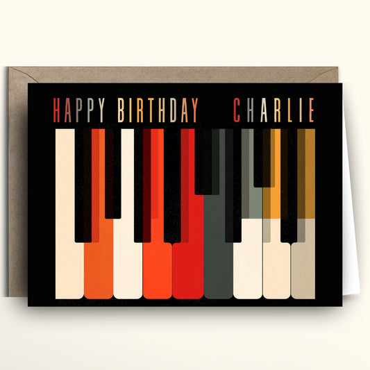 Personalized mid century modern retro piano keys birthday card with Saul Bass style graphic illustration in orange red black and cream.