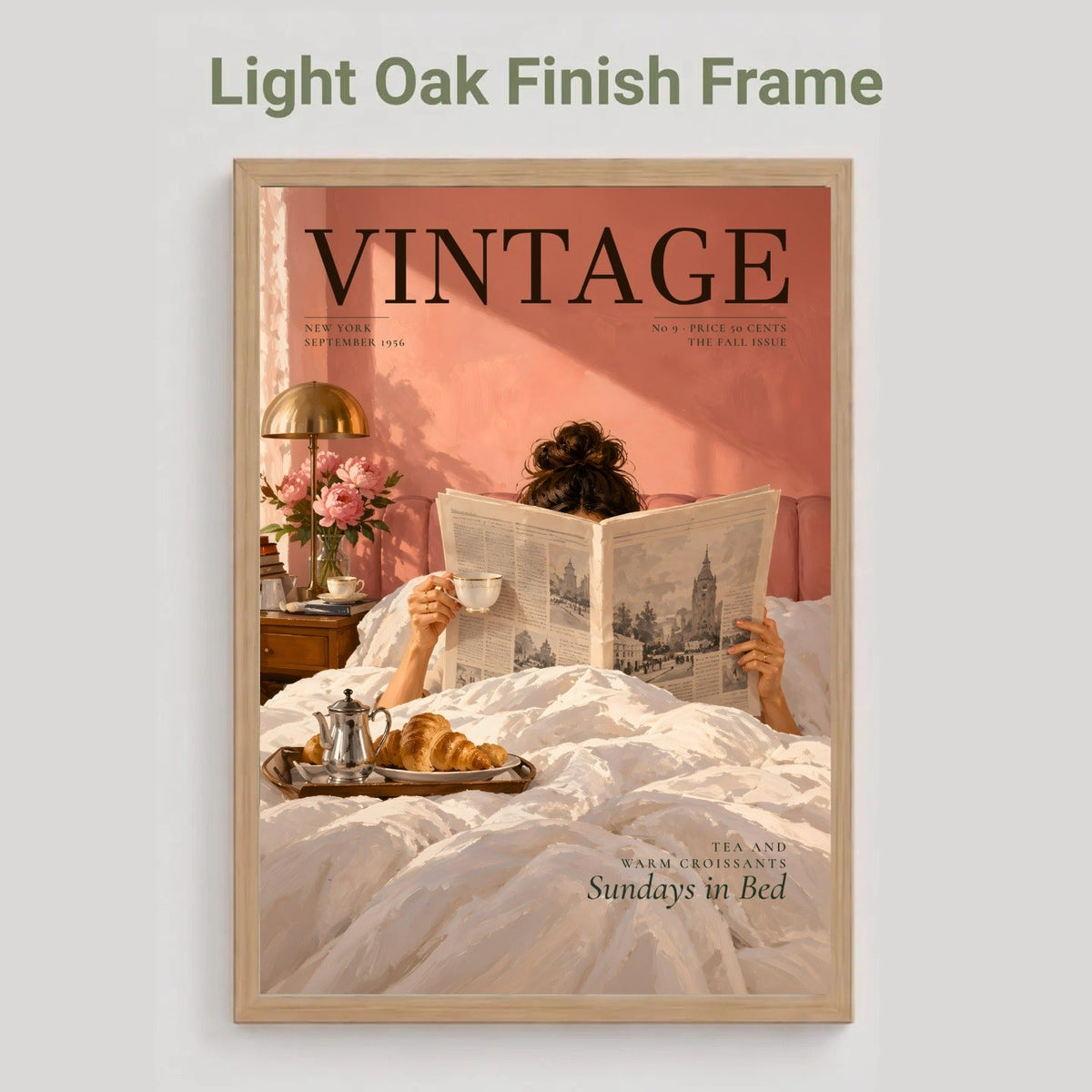 A framed vintage-style poster or magazine cover art shown against a light gray background, with the text 'Light Oak Finish Frame' above it. The artwork features a person reading in bed with a pink wall, white bedding, and a light oak frame.