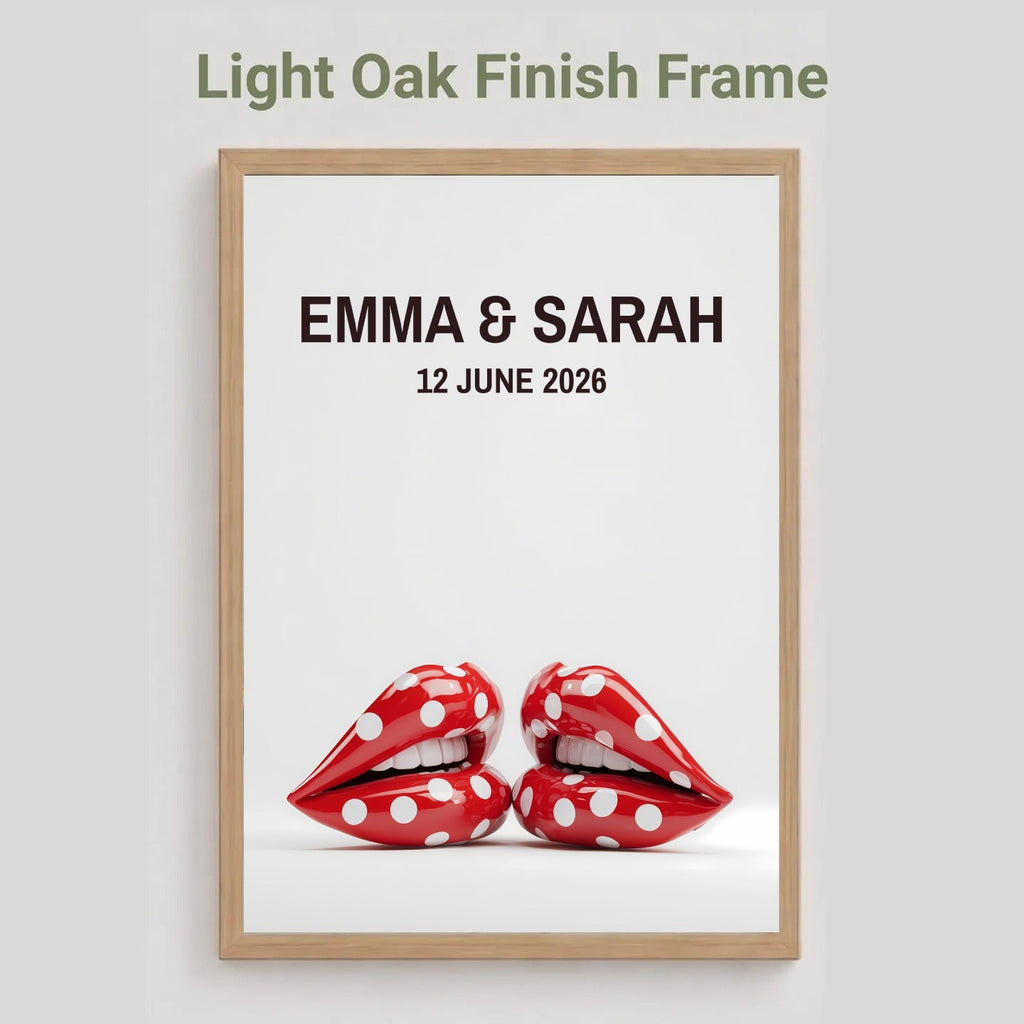 A framed personalized art print with a light oak finish frame, featuring the text 'EMMA & SARAH 12 JUNE 2026' above a pair of red lips with white polka dots, shown against a light gray background with the text 'Light Oak Finish Frame' at the top.