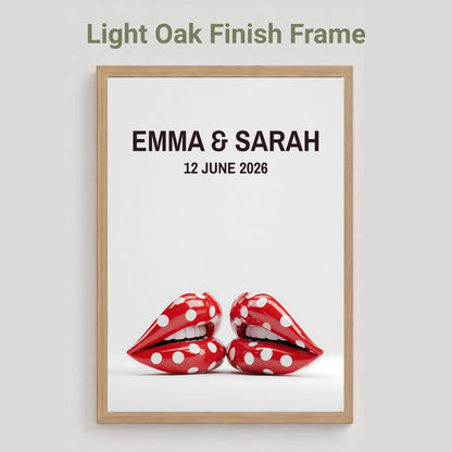 A framed personalized art print with a light oak finish frame, featuring the text 'EMMA & SARAH 12 JUNE 2026' above a pair of red lips with white polka dots, shown against a light gray background with the text 'Light Oak Finish Frame' at the top.