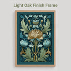 A framed floral art print with a light oak finish frame, shown against a light gray background. The print features a central cream flower with blue and green botanical leaves on a dark teal background.