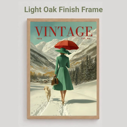 A framed vintage-style art print on a light gray background, with the text 'Light Oak Finish Frame' above it. The artwork shows a woman in a green coat walking in a snowy mountain landscape under a red umbrella, with the word 'VINTAGE' across the top of the print.