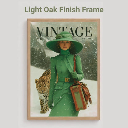 A framed vintage-style poster or magazine cover print hangs on a light gray wall. The artwork shows a woman in a green coat and wide-brim green hat walking in the snow with a leopard, and the word VINTAGE appears at the top.