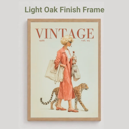 A framed vintage-style poster on a light gray background, with the text 'Light Oak Finish Frame' above it. The poster shows a woman in a pink coat walking with a cheetah, with the word 'VINTAGE' at the top and '1946 vol.